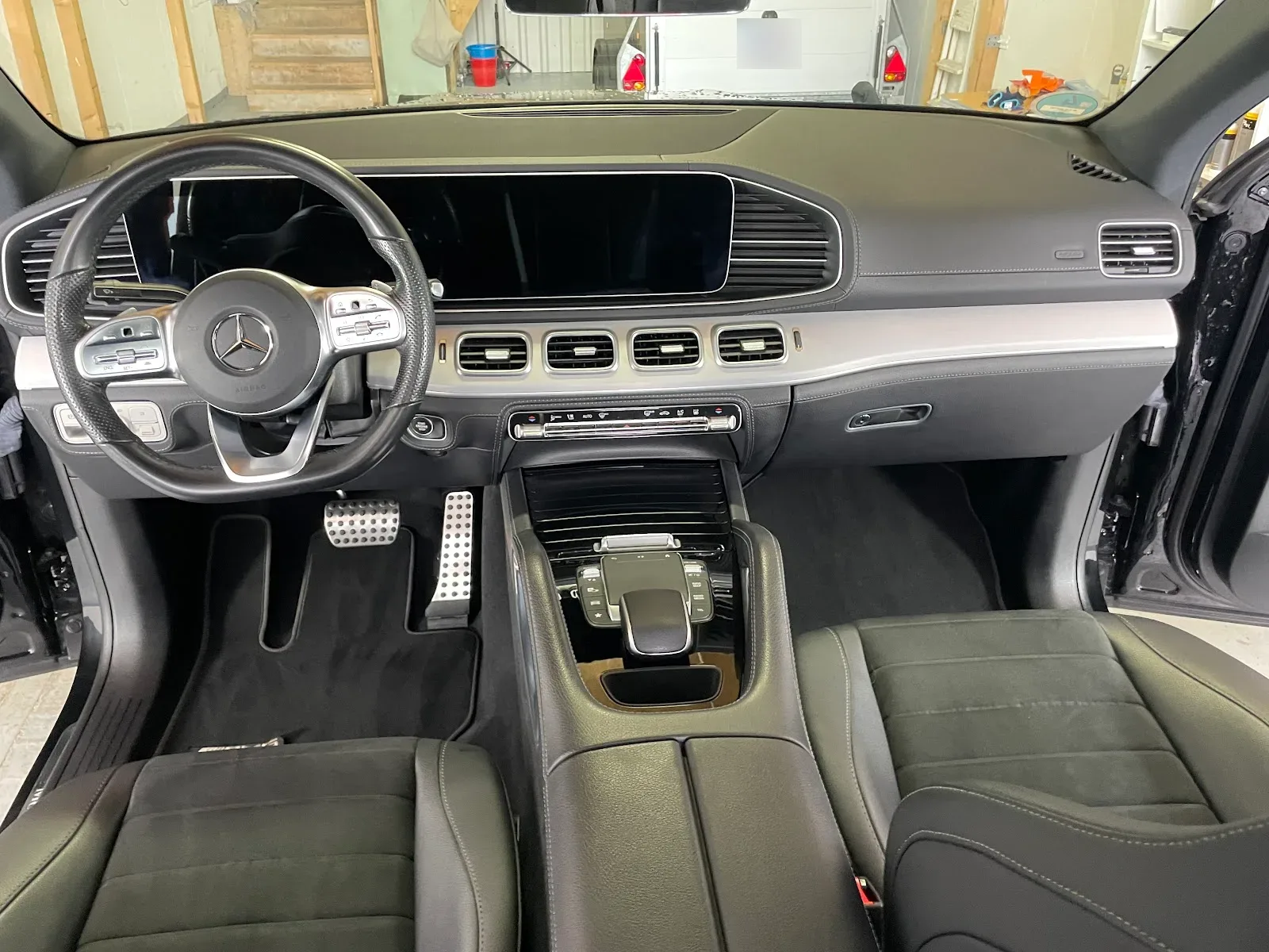 Gereinigtes Cockpit eines Mercedes GLE mit schwarzem Leder, Widescreen-Display und makellosen Fussmatten.